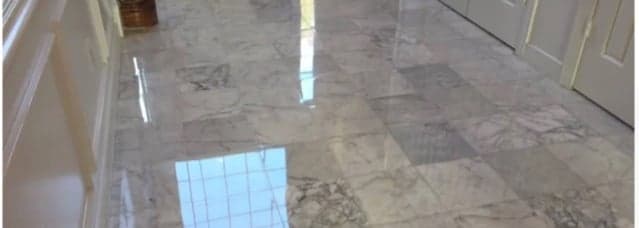 Le même couloir après lustrage : le marbre reflète portes et fenêtres