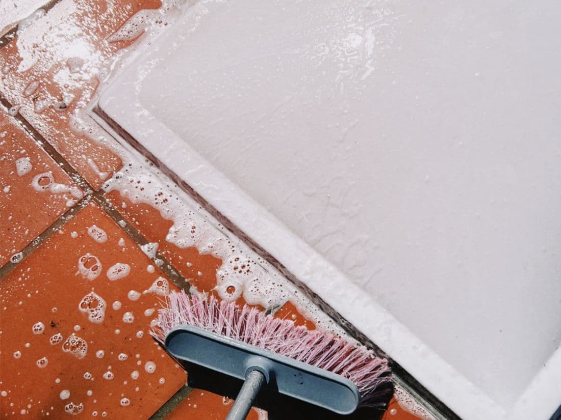 Brosse et mousse sur un carrelage lors d'un nettoyage en profondeur